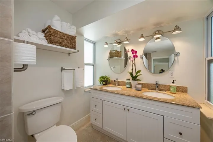 Guest bathroom with shower over tub and travertine floors