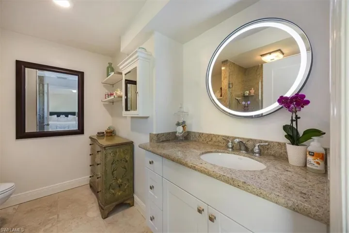 Primary bathroom has a shower granite counters and travertine floors