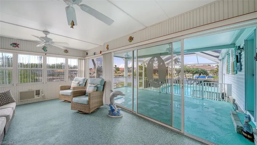 Florida room has sliding glass door to covered lanai and pool