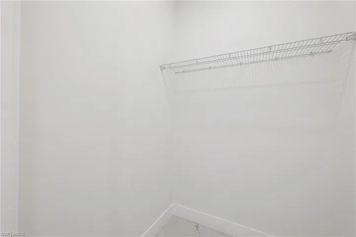 Walk in closet featuring marble finish floor