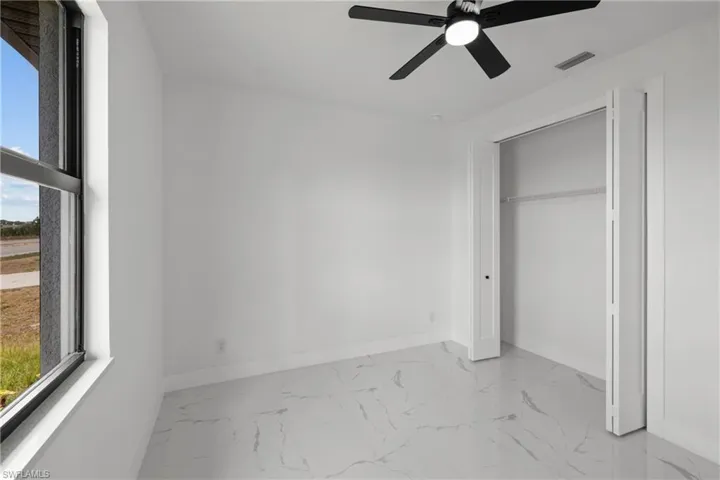 Unfurnished bedroom featuring visible vents, marble finish floor, baseboards, and multiple windows