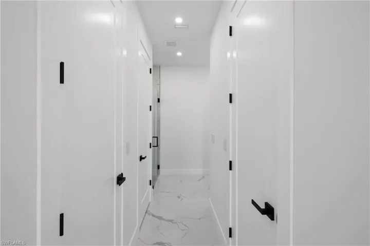 Corridor with baseboards, recessed lighting, marble finish floor, and visible vents