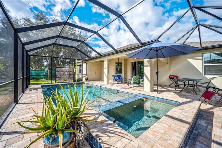 Integrated pool / spa featuring a patio area, a sunroom, glass enclosure, and outdoor dining area