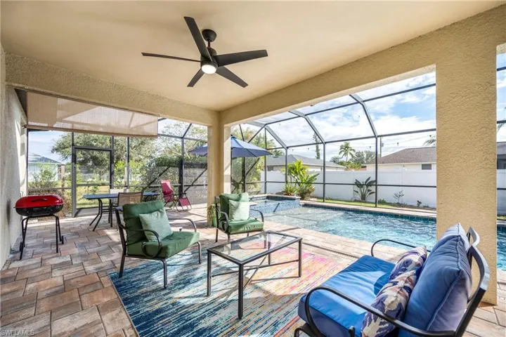 View of patio with a lanai, a sunroom, grilling area, and ceiling fan