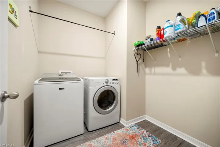 Laundry room with wood finished floors and independent washer and dryer