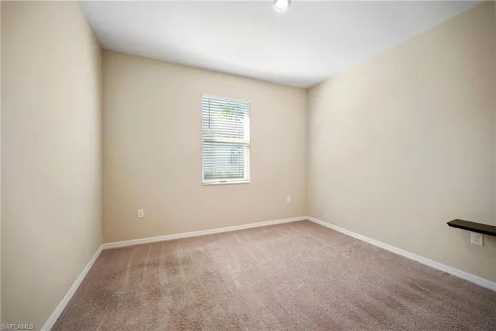 Carpeted empty room featuring baseboards