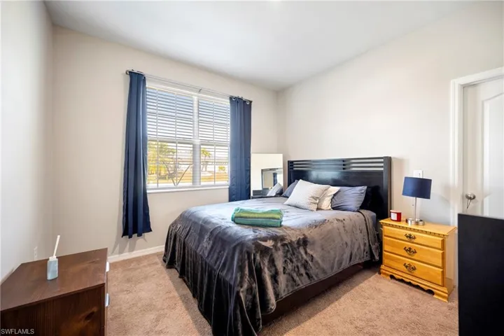 Bedroom featuring light colored carpet and baseboards