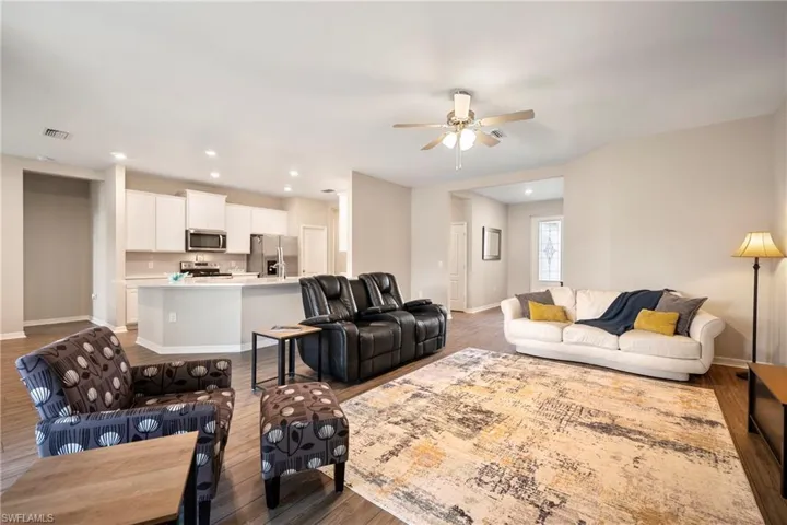 Living room featuring wood finished floors, a ceiling fan, and recessed lighting