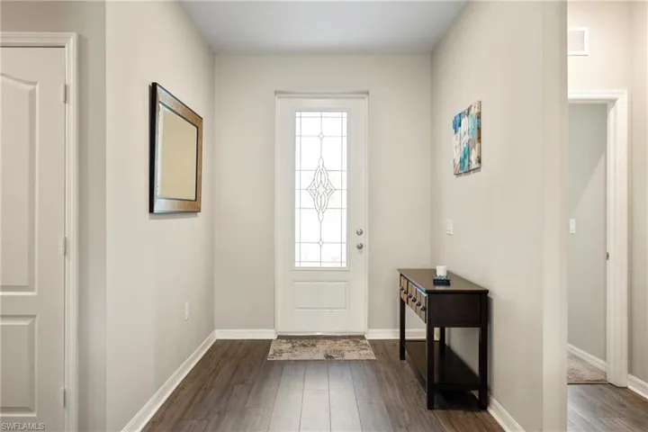 Entryway with dark wood finished floors and baseboards