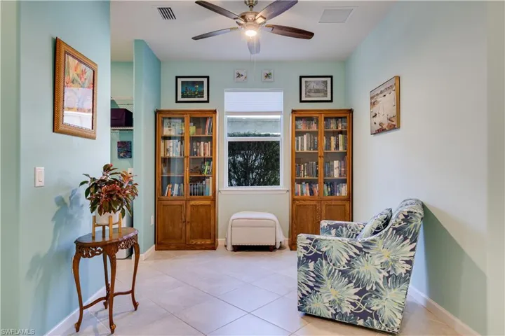 Sitting room with tile patterned floors and a ceiling fan