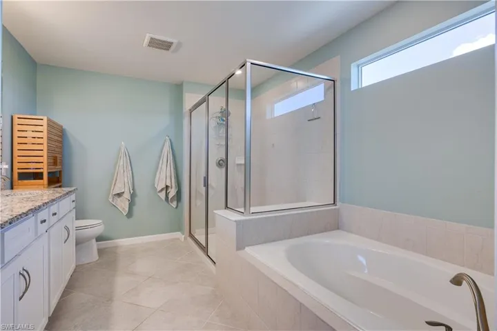 Full bathroom with vanity, a stall shower, light tile patterned floors, and a garden tub