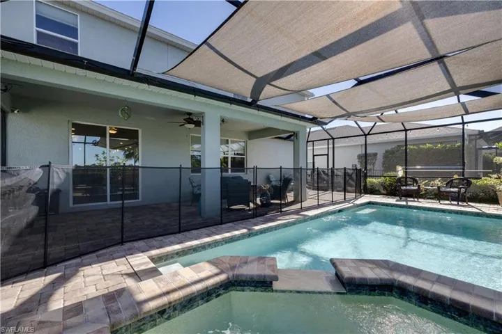 View of pool with a lanai  enclosure, a patio, and a pool with connected hot tub