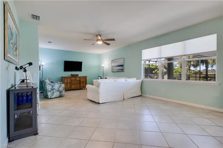 Living room with ceiling fan and light tile patterned floors