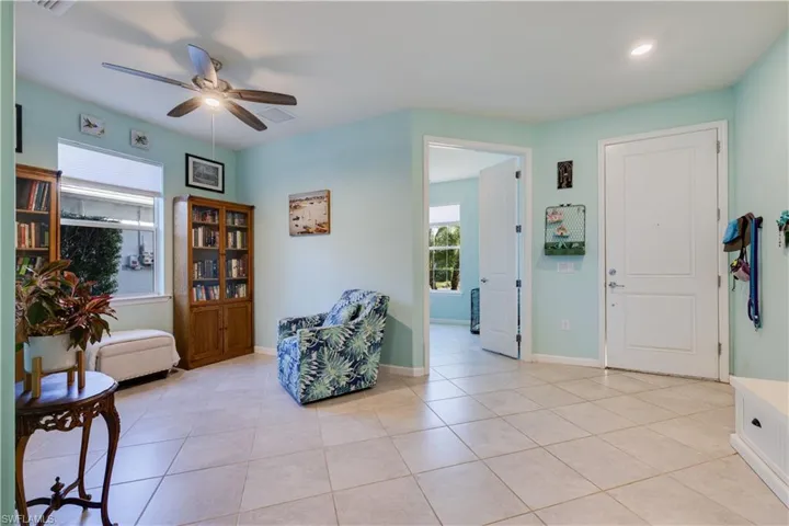 Living area featuring light tile patterned flooring and a ceiling fan