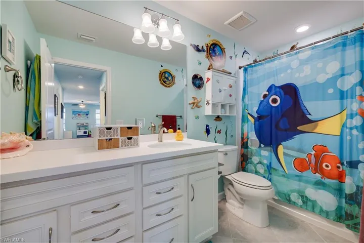 Bathroom featuring light tile patterned flooring, vanity, and recessed lighting