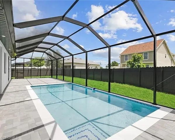 View of pool featuring a sunroom, glass enclosure, a patio, and a fenced backyard