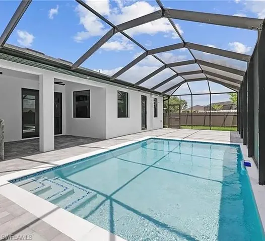 View of swimming pool featuring a sunroom, a patio area, and a lanai