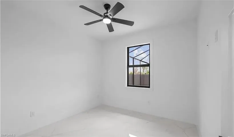 Unfurnished room featuring a ceiling fan and marble finish floors