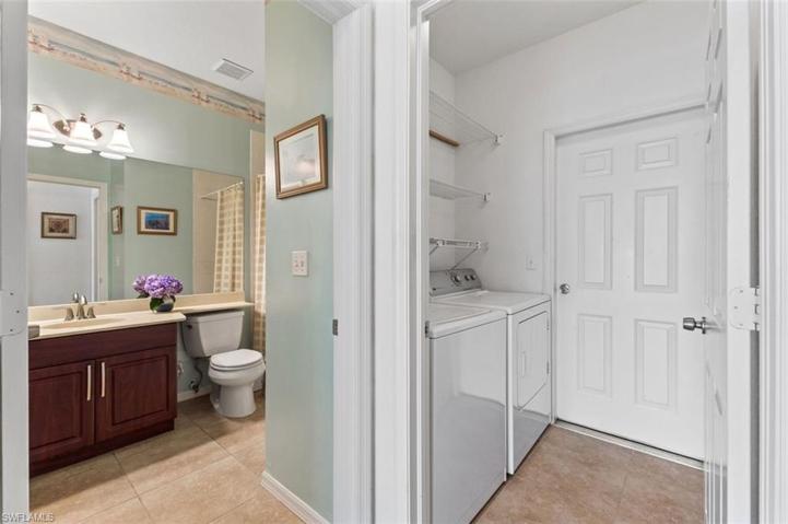 View from hallway....featuring guest bath and laundry room with full sized washer/dryer
