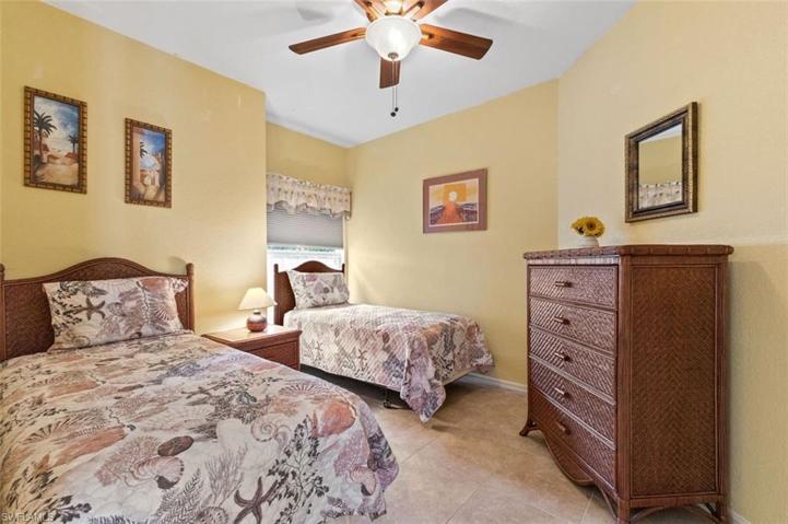 Spacious bedroom with tile floor and ceiling fan ....so inviting and just perfect for visitors....