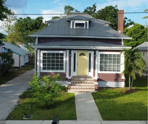 View of front of home featuring covered porch and a front lawn