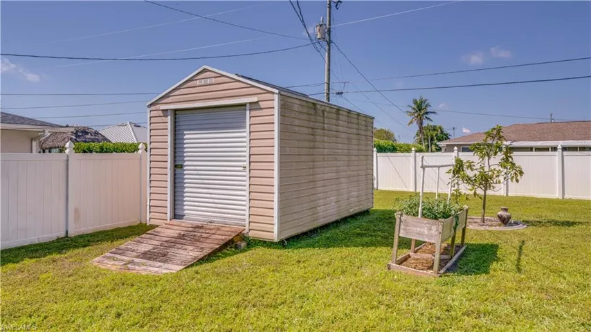View of shed with a vegetable garden and a fenced backyard