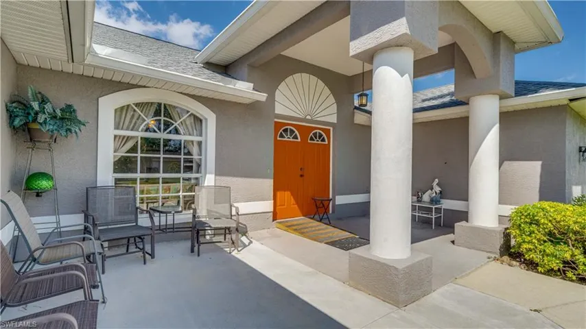 Doorway to property with stucco siding and roof with shingles