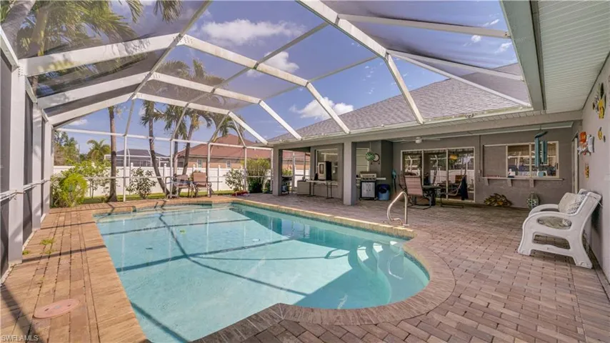 View of pool featuring a fenced in pool, glass enclosure, and a patio area