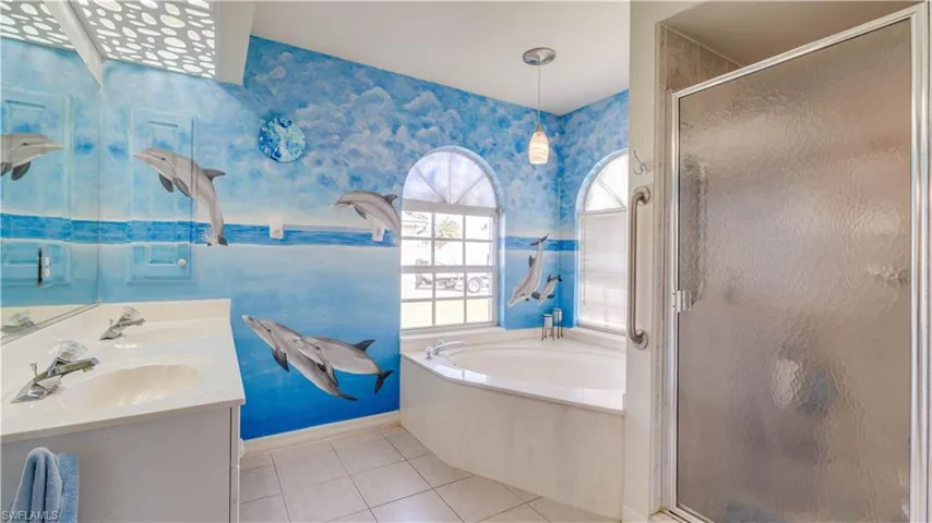 Bathroom with a sink, a stall shower, tile patterned flooring, and wallpapered walls