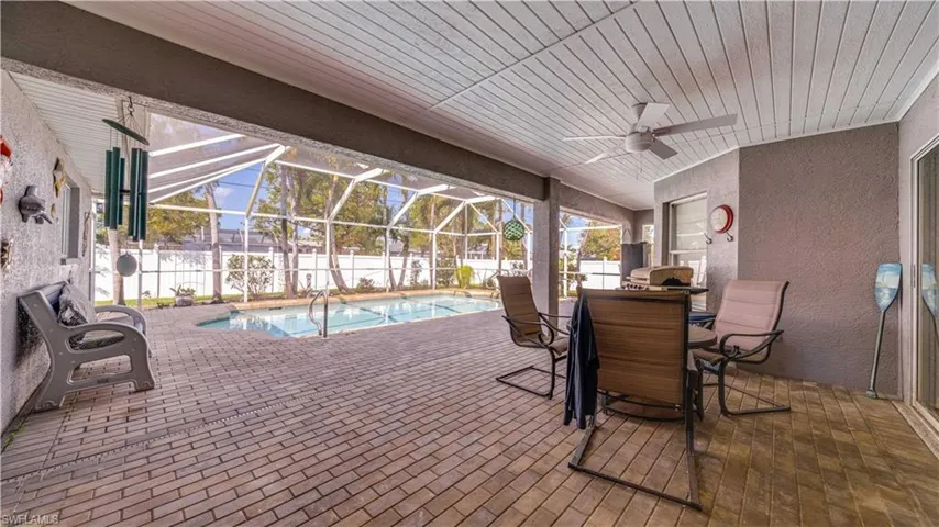 View of swimming pool with glass enclosure, a patio, a ceiling fan, a fenced in pool, and fence private yard