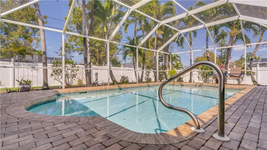 View of pool featuring a patio area, glass enclosure, and a fenced backyard