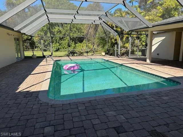 Swimming pool featuring a patio, a lanai, and a sunroom