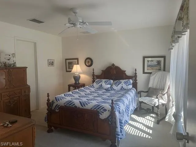 Carpeted bedroom featuring ceiling fan