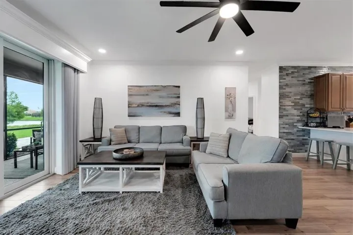 Sliding glass doors leading to an outdoor living area, wood-finish flooring, recessed lighting, and a contemporary ceiling fan