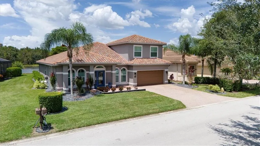 Two-story residence with a tile roof, paved driveway, and an attached two-car garage