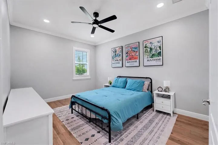 Recessed lighting, wood-finish flooring, ceiling fan, crown molding, and window with plantation shutters
