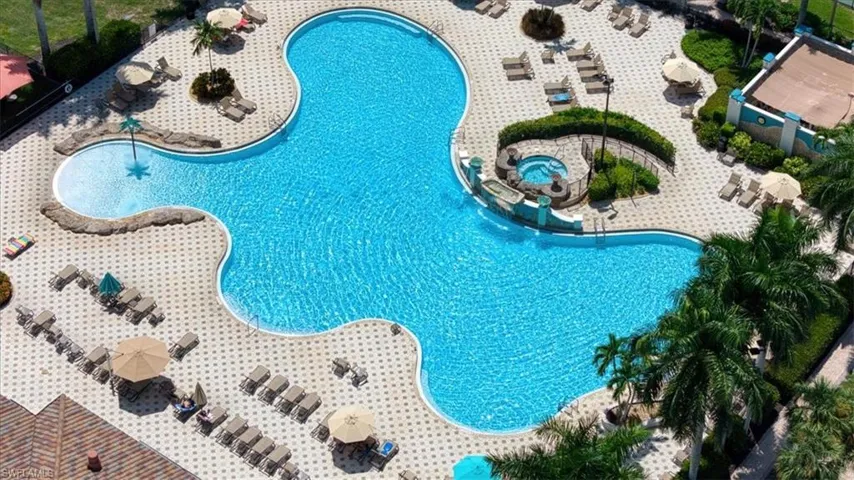 Resort-style pool with a distinct freeform shape, integrated spa, and a separate shallow water entry