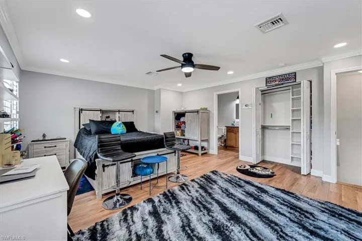 Wood-finish flooring throughout, recessed lighting, ceiling fan with integrated lighting, crown molding, and built-in closet shelving