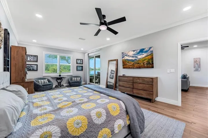 Recessed lighting, crown molding, a ceiling fan, a window with blinds, and glass sliding doors