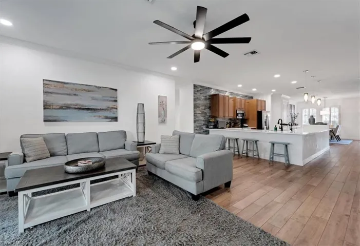 Open-concept living space featuring wood-finish flooring, recessed lighting, and a modern ceiling fan