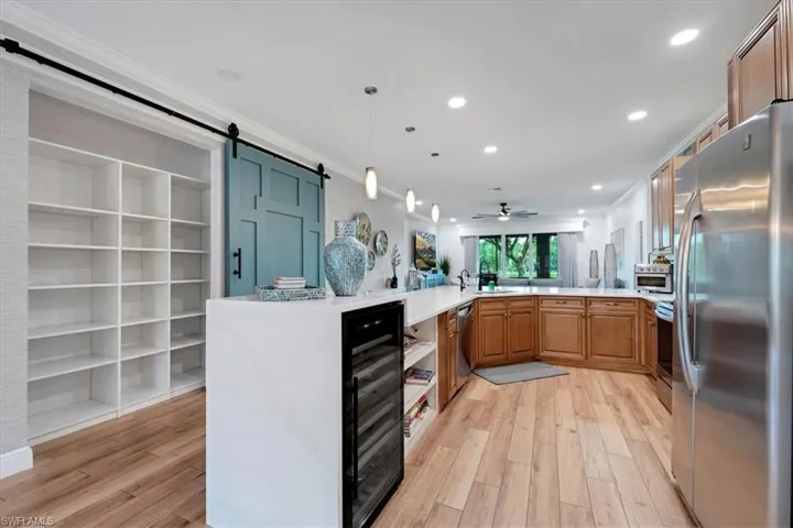 Spacious kitchen featuring wood-finish flooring, recessed lighting, and stainless steel appliances