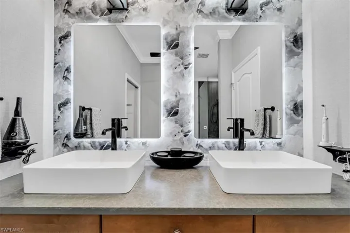 Dual rectangular vessel sinks with matte black fixtures, set on a gray countertop with wood-finish cabinetry