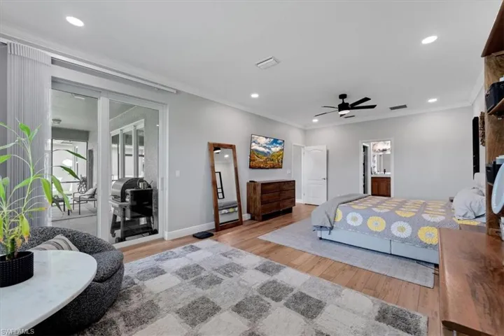Wood-finish flooring with crown molding, recessed lighting, and a ceiling fan