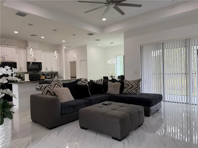 Living room featuring recessed lighting, light marble finish floors, and ceiling fan