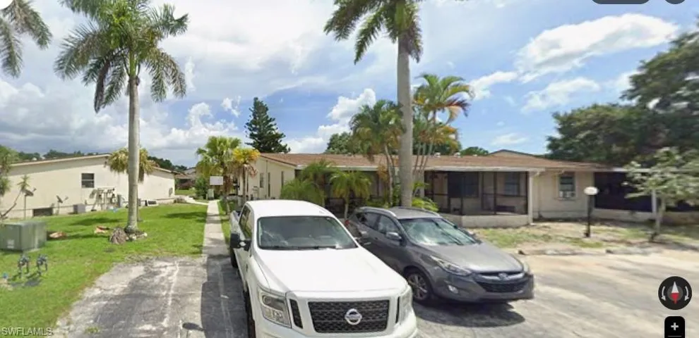 View of front of property with a front yard, a residential view, and uncovered parking