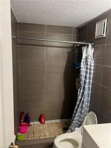 Bathroom featuring a shower stall, vanity, and a textured ceiling