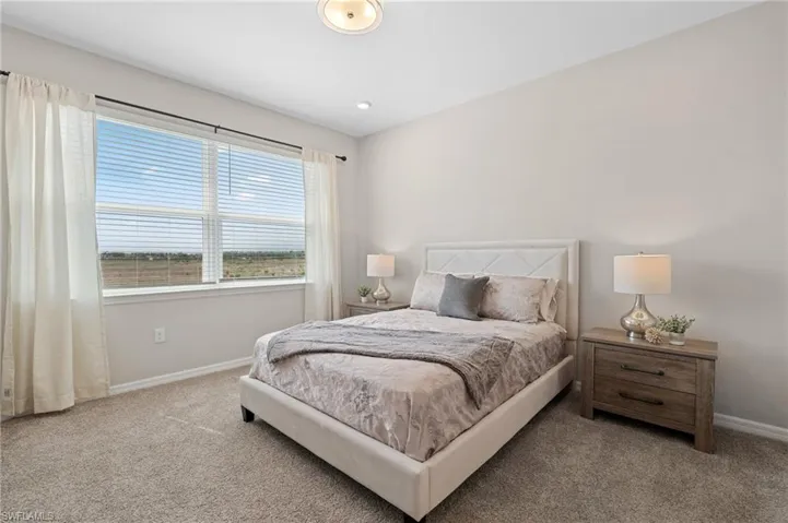 Bedroom featuring carpet and baseboards