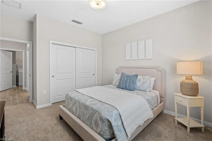 Bedroom with baseboards, visible vents, washer / clothes dryer, and a closet