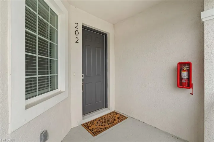 Townhome / multi-family property featuring driveway, a garage, stairway, a tiled roof, and stucco siding