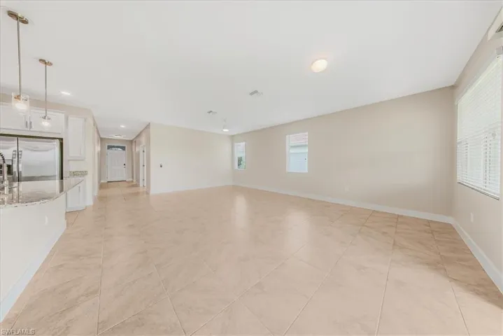 Spare room featuring baseboards and light tile patterned flooring